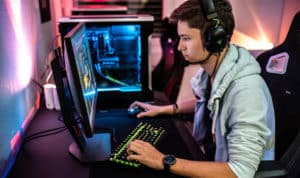Man sitting at computer with headphones avoiding esports risks