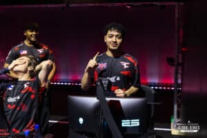 Two members of the FaZe roster, pictured at the ALGS Split 2 Playoffs shortly after being signed. Naghz stares straight into the camera while holding up one finger, showing off after winning a game. Sinetic is pictured off to the side, hand over his face to cover his emotion.