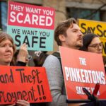 Protesters in Edinburgh campaigning after the controversial Rockstar Layoffs. One protester holds a sign that reads "Grand Theft Employment"
