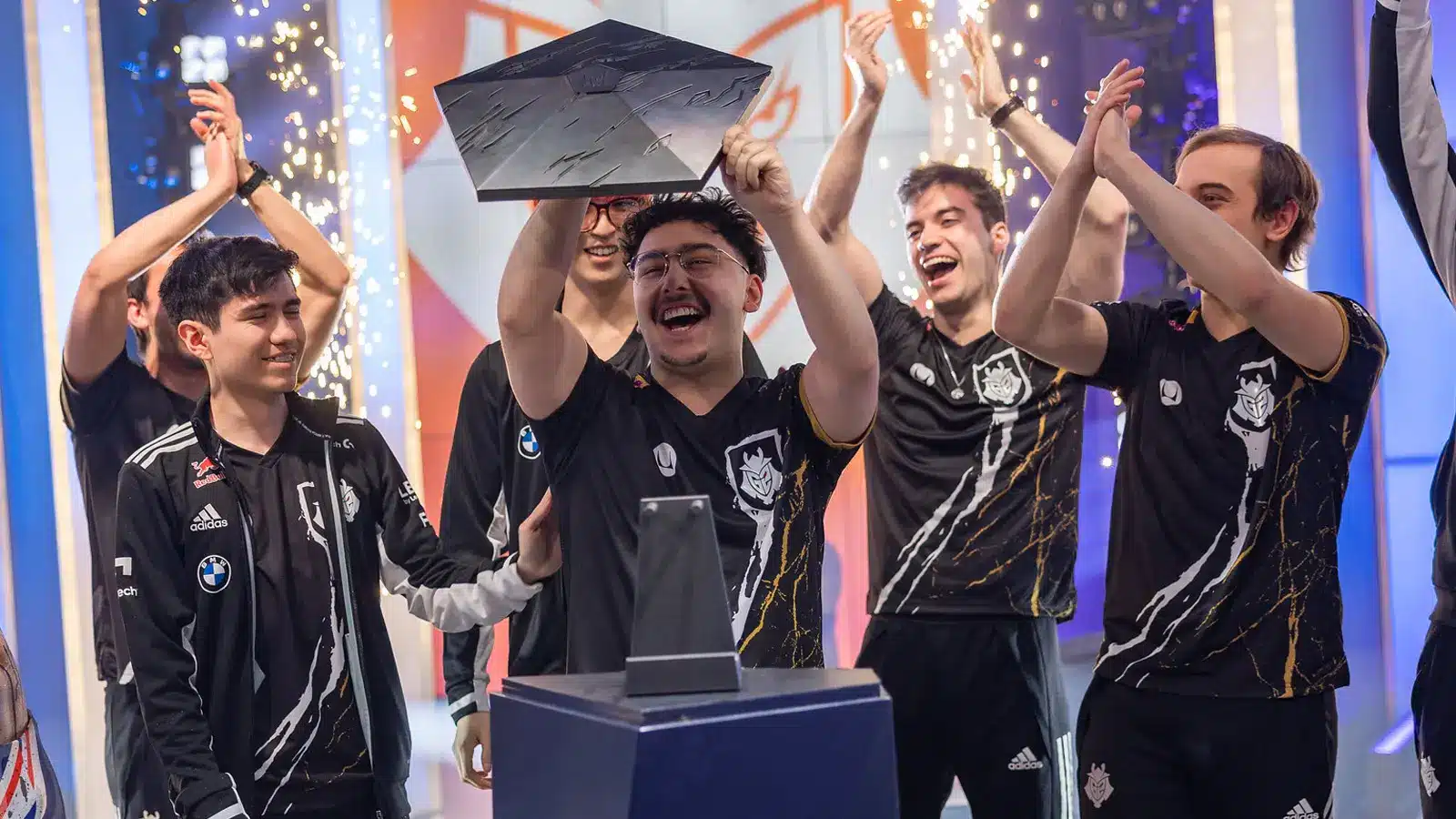 G2 Esports League of Legends team celebrating with a trophy after victory.
