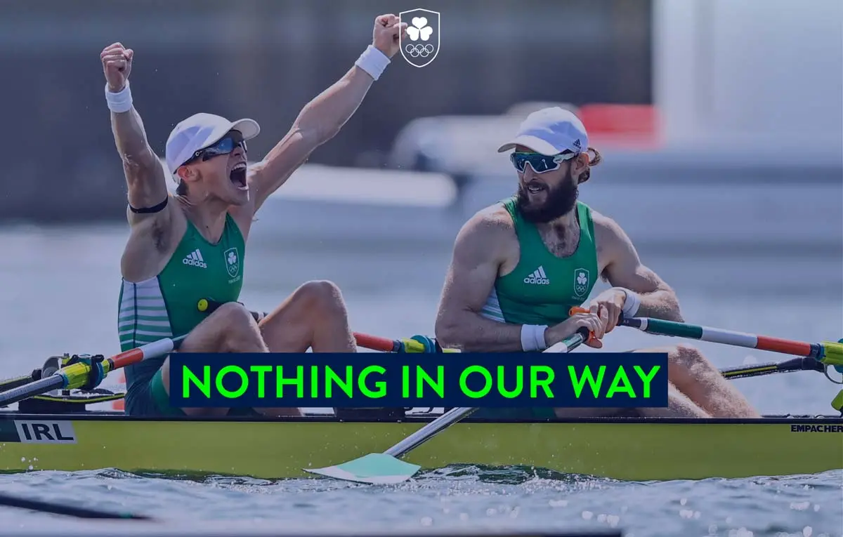 Two male rowers celebrating in a racing boat during a competition.