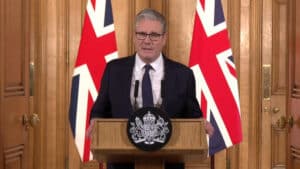 Kier Starmer with two union jacks in the backdrop.