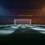 Floodlit World Cup stadium pitch at golden hour, packed stands with dramatic shadows, national colours in lighting design.